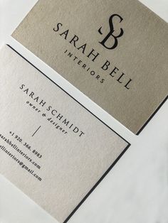 two business cards sitting on top of each other with the letter s in black and white