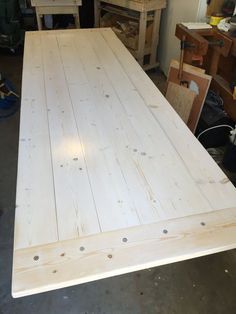 a large wooden table being made in a workshop