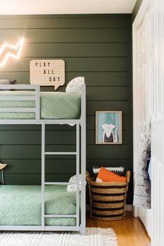 there is a bunk bed in the corner of this room with green walls and wood floors