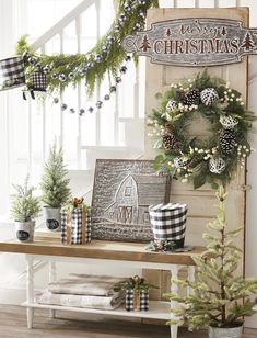 a christmas display with pine cones, evergreens and other holiday decorations on a table