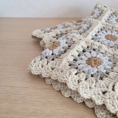 a crocheted blanket is laying on a table