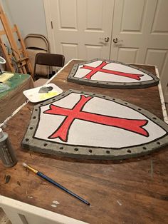 two large signs sitting on top of a wooden table next to a painting easel