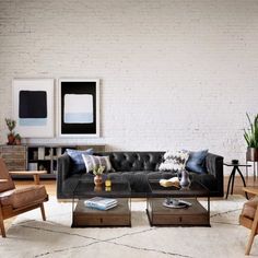 a living room with white brick walls and furniture in the corner, including a black couch