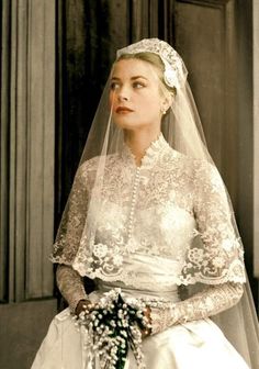 an old photo of a woman wearing a wedding dress and veil with flowers in her hair