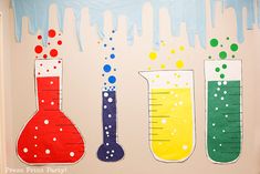 three beaks with colored liquids and bubbles in them