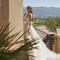 a woman in a wedding dress standing on a balcony