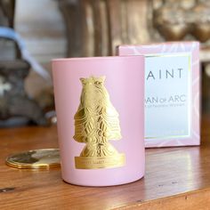 a pink candle sitting on top of a wooden table