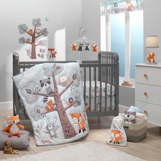 a baby crib with an animal themed bedding set and stuffed animals on the floor