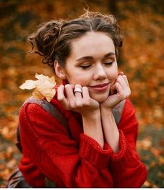 a woman sitting on the ground with her hands under her chin