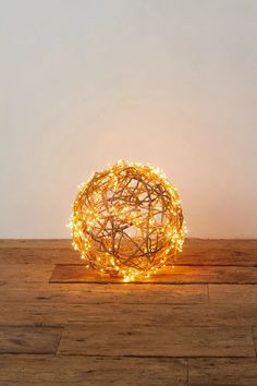 a ball shaped light on top of a wooden floor