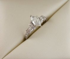 a diamond ring sitting on top of a white cloth