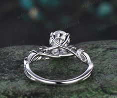 a white gold engagement ring with an intricate design on the band and center stone in the middle