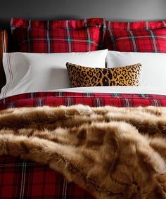 a red and black plaid bed spread with white pillows