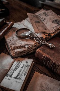 an old book with a magnifying glass on it next to some other books