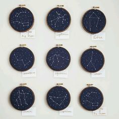 nine embroidery hoops with zodiac signs on them