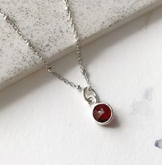 This red garnet necklace is so dainty and light. January birthstone. A small faceted gemstone pendant is set in sterling silver. The perfect crystal jewelry for everyday wear.  If you want to add more charms to your necklace, please contact me. More gemstones available here: https://www.etsy.com/ca/shop/annielesperance?ref=seller-platform-mcnav&section_id=6733458 * SIZE: 6mm stone * LENGTH: 18 inches (16 inches available on demand) * MATERIAL: Sterling silver, faceted gemstone Minimalist Red Gemstone Birthstone Necklace, Minimalist Red Birthstone Necklace, Red Faceted Sterling Silver Necklace, Silver Garnet Birthstone Necklace, Faceted Sterling Silver Birthstone Necklace With Round Pendant, Delicate Silver Birthstone Necklace, Red Dainty Birthstone Necklace, Red Minimalist Birthstone Necklace, Silver Faceted Sterling Silver Birthstone Necklace