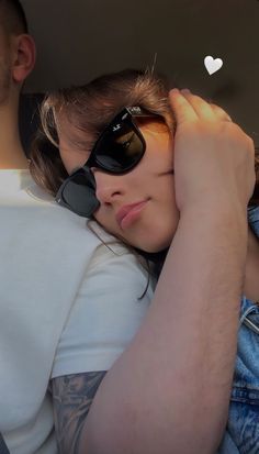 a man and woman sitting in the back seat of a car with their arms around each other