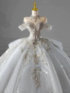 a white wedding dress with silver sequins on the skirt and gold headpiece