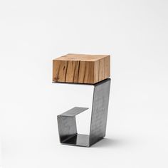 a wooden object sitting on top of a metal stand