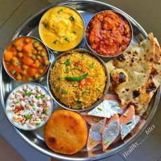 a metal tray topped with lots of different types of food