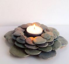 a candle that is sitting in some kind of plant with rocks on it's sides