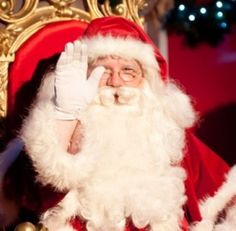 a man dressed as santa clause sitting in a chair with his hand up to his face