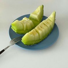 two pieces of fruit on a blue plate with a fork