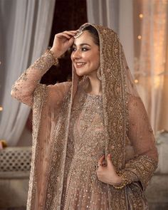 a woman in a bridal outfit posing for the camera with her hand on her head