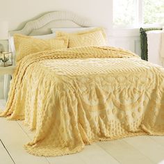 a bed with yellow bedspread and pillows