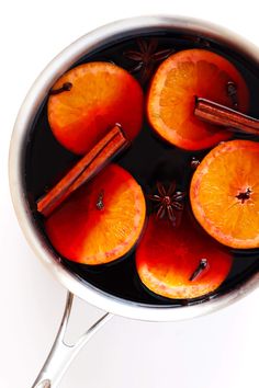 orange slices and cinnamon sticks are in a pot