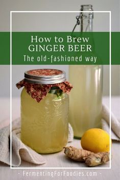 a glass jar filled with ginger beer next to a lemon