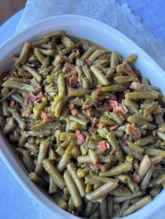 a white bowl filled with green beans and bacon