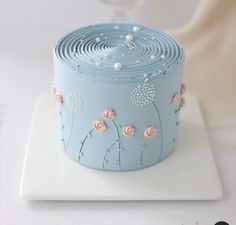 a blue cake with pink flowers on it