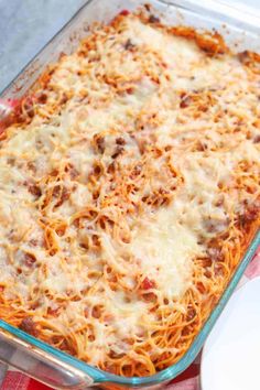 a casserole dish with meat and cheese in it on a checkered table cloth