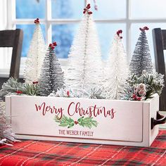 a wooden box filled with christmas trees sitting on top of a table