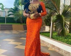 This stunning orange gown is a perfect choice for any special occasion. It features a one long sleeve with a mermaid cut and is designed in African style. Made from high-quality materials, this dress is sure to make you stand out from the crowd. It's perfect for a wedding, prom, or any formal event. Its vibrant orange color and intricate African design make it a great choice for any dinner date. The delicate and intricate details will ensure all eyes are on you. The unique African style makes this dress perfect for all shapes and sizes, and it will look great with any accessories you choose to pair it with. Perfect for any special occasion, this orange gown is sure to make you the star of the night. Note: Please note that the exact fabric might not be available as at when ordered. However, Wedding Dress African Style, Dress African Style, Mermaid Dress Wedding, Asoebi Dress, Dinner Date Dress, African Prom Dress, Lace Styles For Wedding, Long Sleeve Mermaid Dress, Nigerian Lace Styles Dress