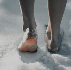 a person standing in the snow with their bare feet sticking out from it's toe