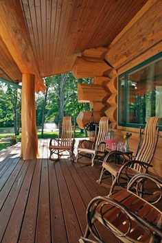 a wooden porch with rocking chairs on it