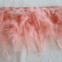 pink feathers are lined up on a white towel