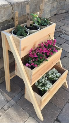 three planters are stacked on top of each other with flowers growing in the bottom