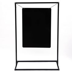 a black and white photo hanging on a clothes rack with an empty sheet of paper in front of it