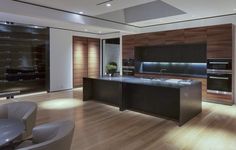 a large kitchen with wooden floors and black cabinets