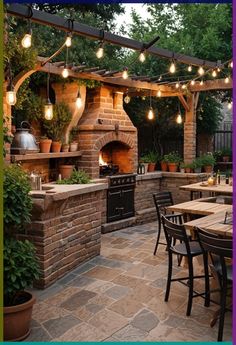 an outdoor kitchen and dining area with lights strung from the ceiling over the grill, surrounded by potted plants