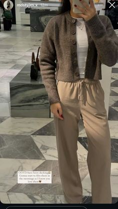 a woman taking a selfie with her cell phone in front of her face while standing on a marble floor