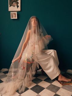 a woman sitting on the floor wearing a veil