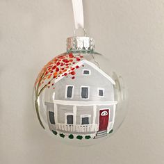 a glass ornament with a house painted on it