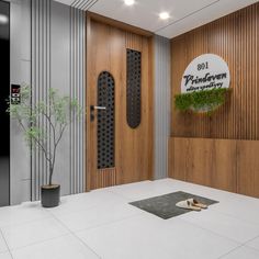 the entrance to an office building with wood paneling and metal door handles, potted plant in front of it