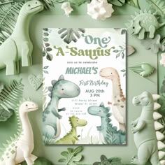 a birthday card with dinosaurs and leaves on the bottom, in front of a green background