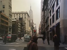 people are walking down the street in an old city with tall buildings and skyscrapers