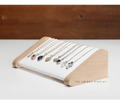 a wooden stand with several necklaces on it